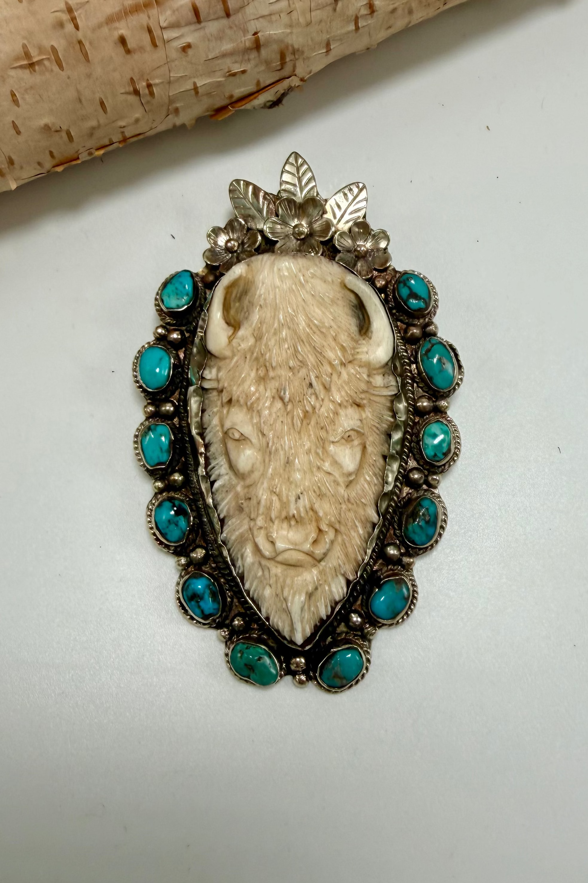 Carved bison, head with turquoise and flowers
